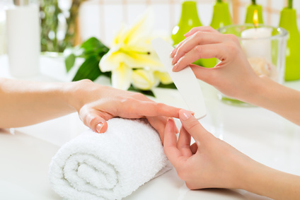 Woman in a nail salon receiving a manicure by a beautician